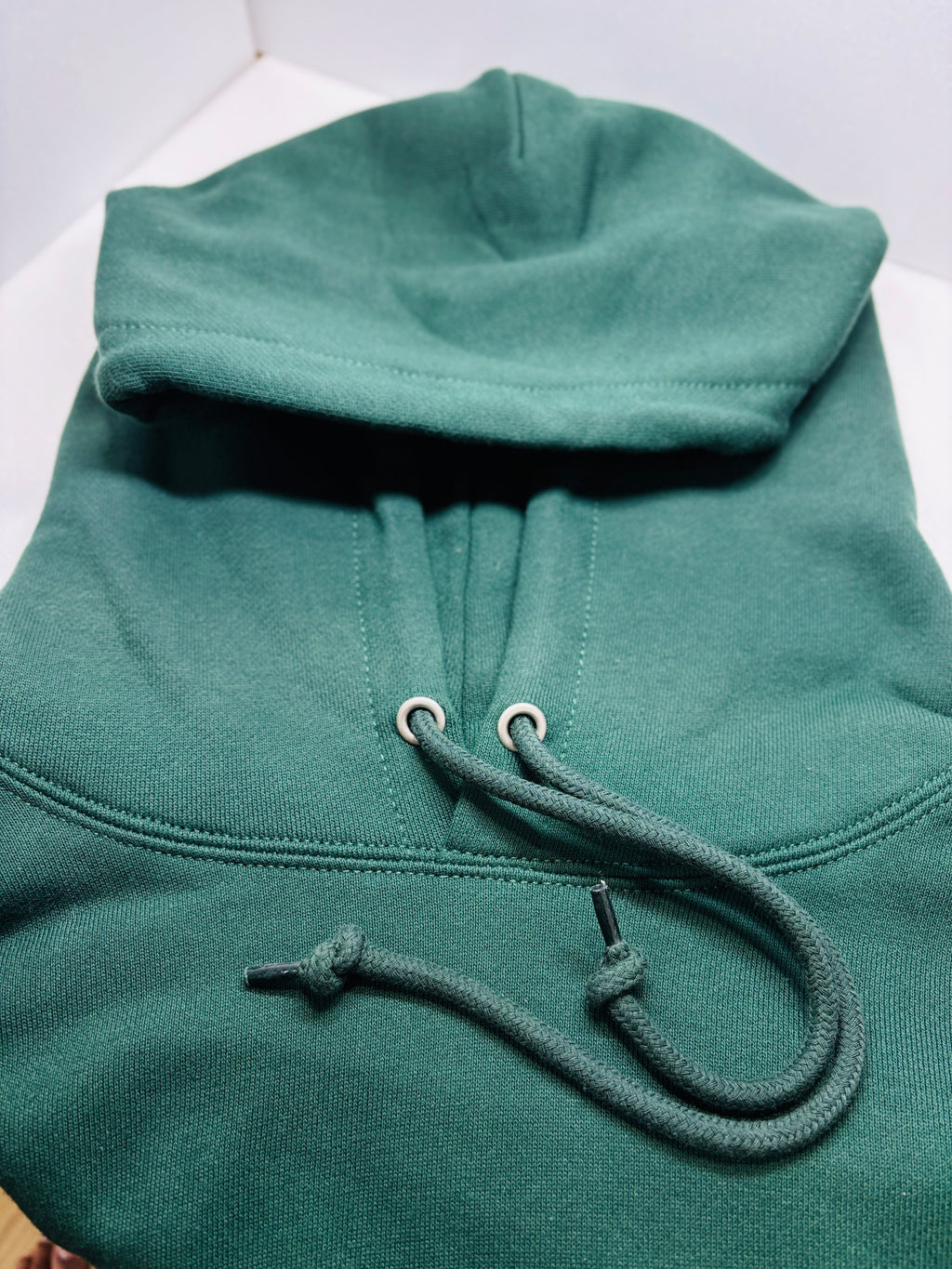 Green hoodie with a drawstring on a white background