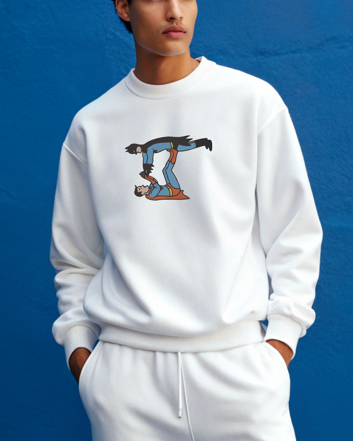Person wearing a white sweatshirt with a graphic design on a blue background